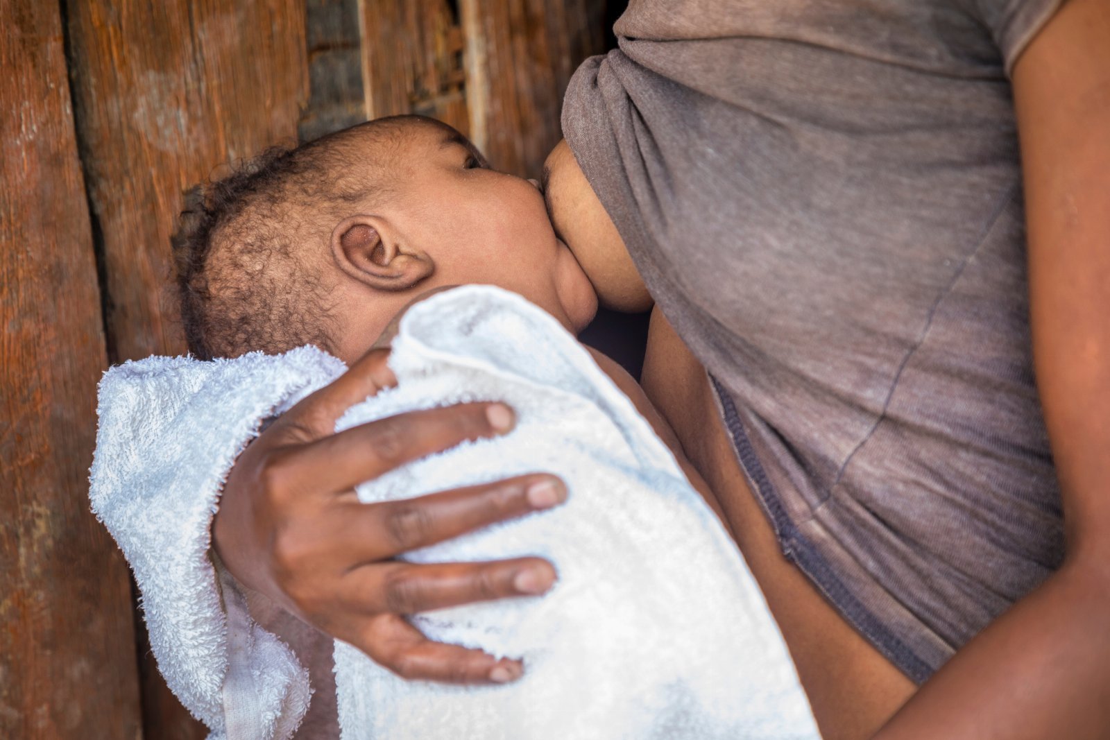 Mãe amamentando seu bebê com apoio e proximidade.
